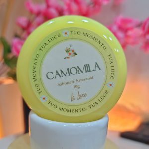 Sabonete artesanal La Luce Camomila, 80g, rótulo amarelo-claro com ilustração de flores de camomila.