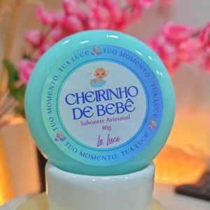 Sabonete artesanal La Luce Cheirinho de Bebê, 80g, rótulo azul-esverdeado com ilustração de bebê.